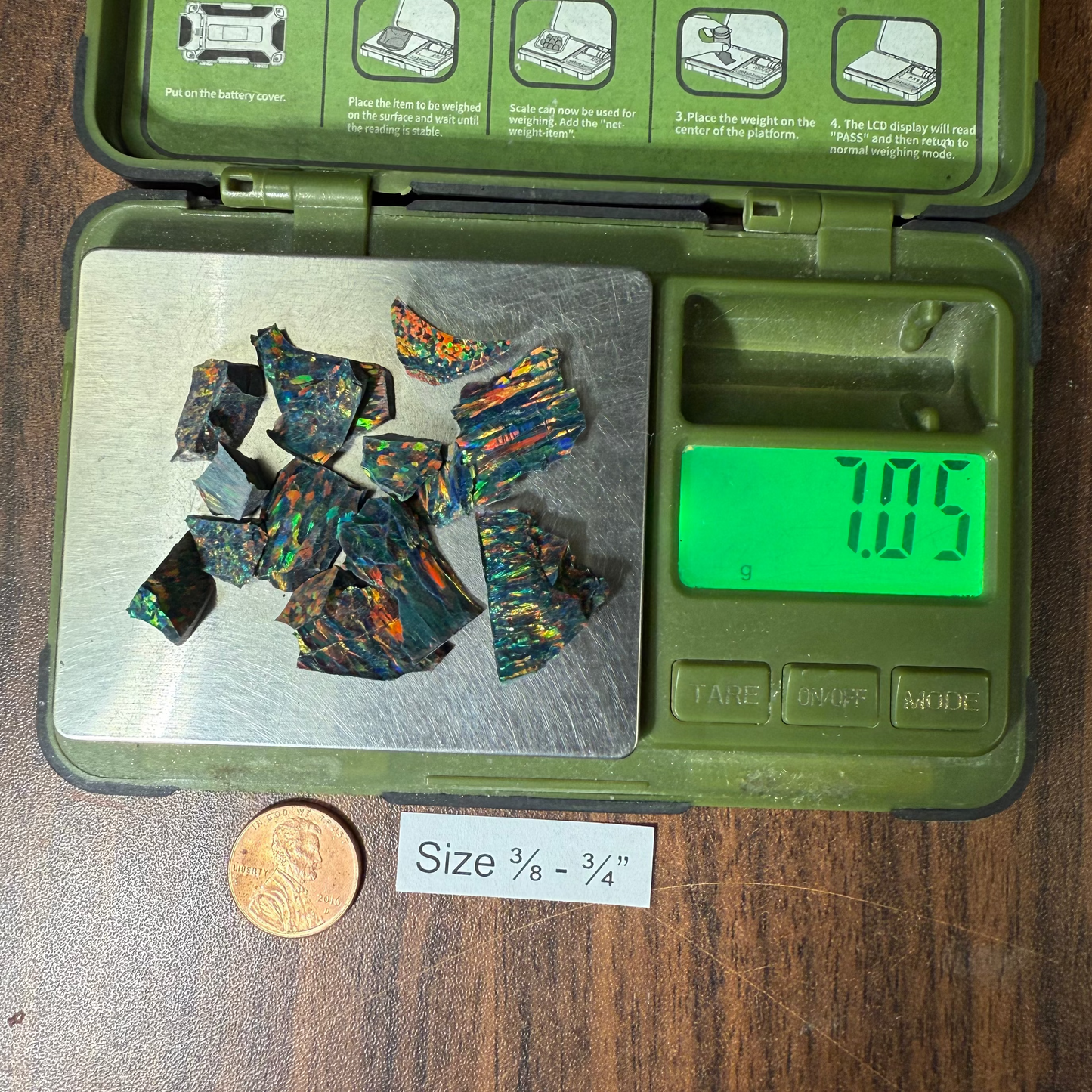 3/8" - 3/4" opal and a penny for size reference on a wooden surface