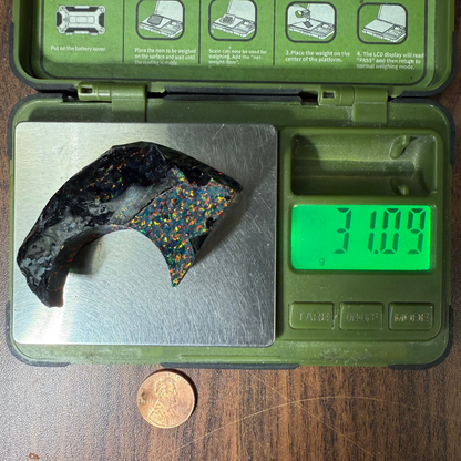 Opal remnant on a digital scale with a green case displaying instructions