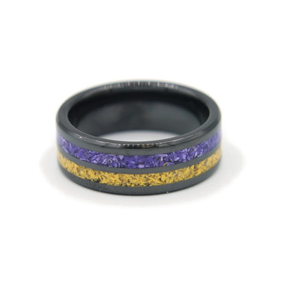 Black ceramic double-channel ring inlaid with purple and yellow Colorstone, lying flat on white