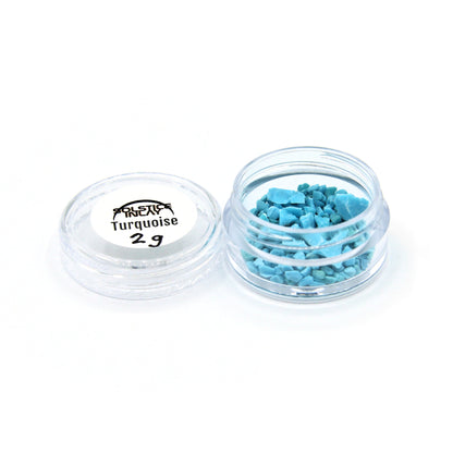A 2 g jar of turquoise fragments with its label